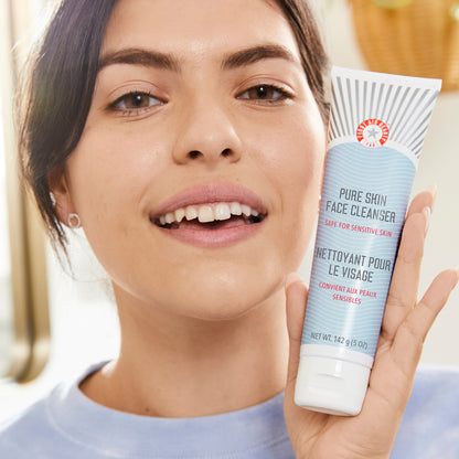 Model holding up Face Cleanser in hand