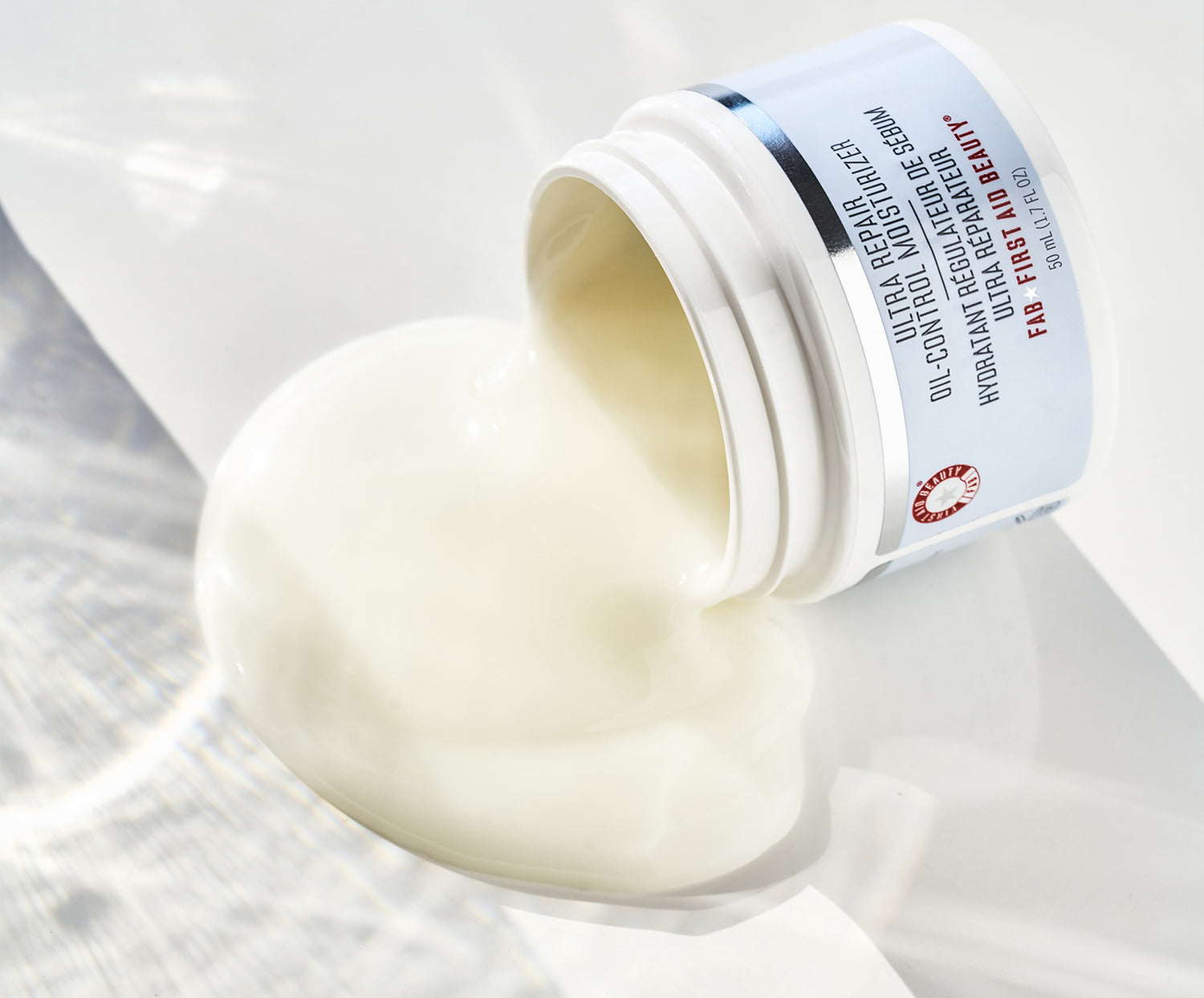 Product shot of Ultra Repair Oil-Control Moisturizer tilted with product spilling out to show texture up close.